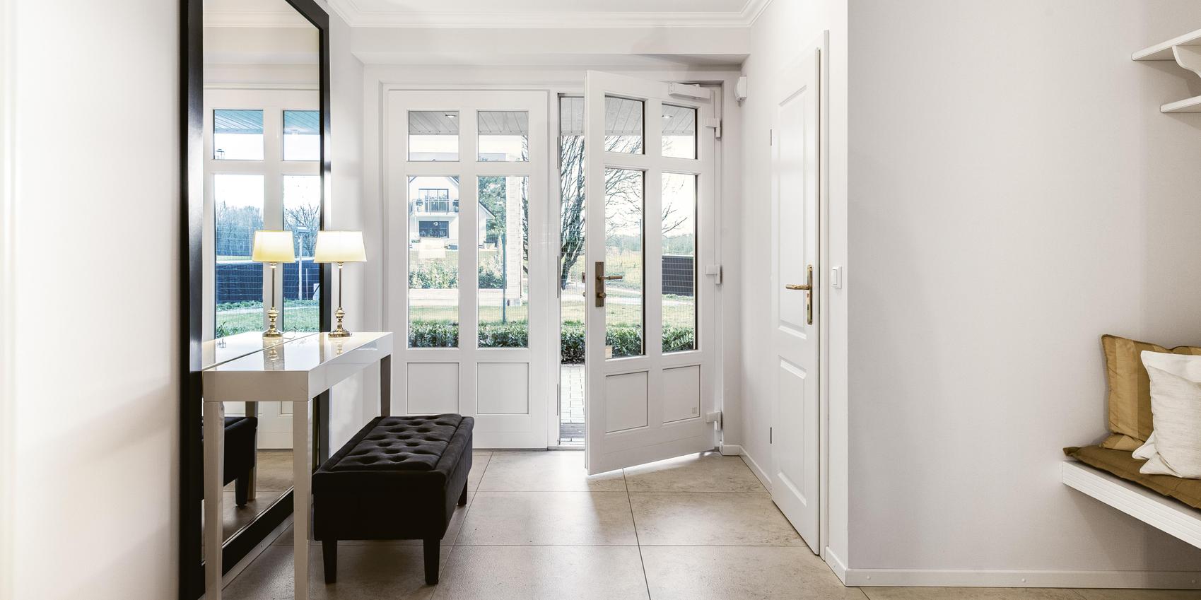 Blick von innen durch den Eingangsbereich zu einer offenen Haustür.