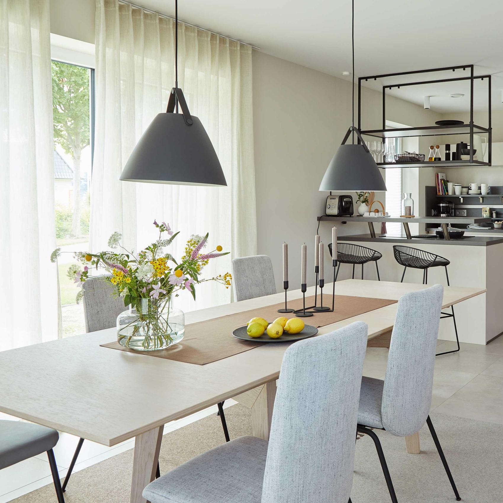 Blick auf einen Essbereich mit offener Küche.