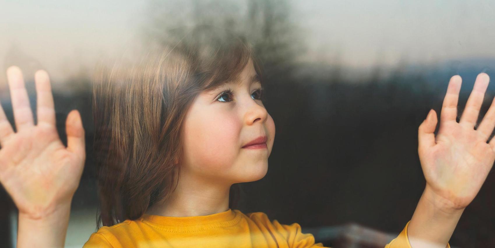 Kind schaut durch Scheibe