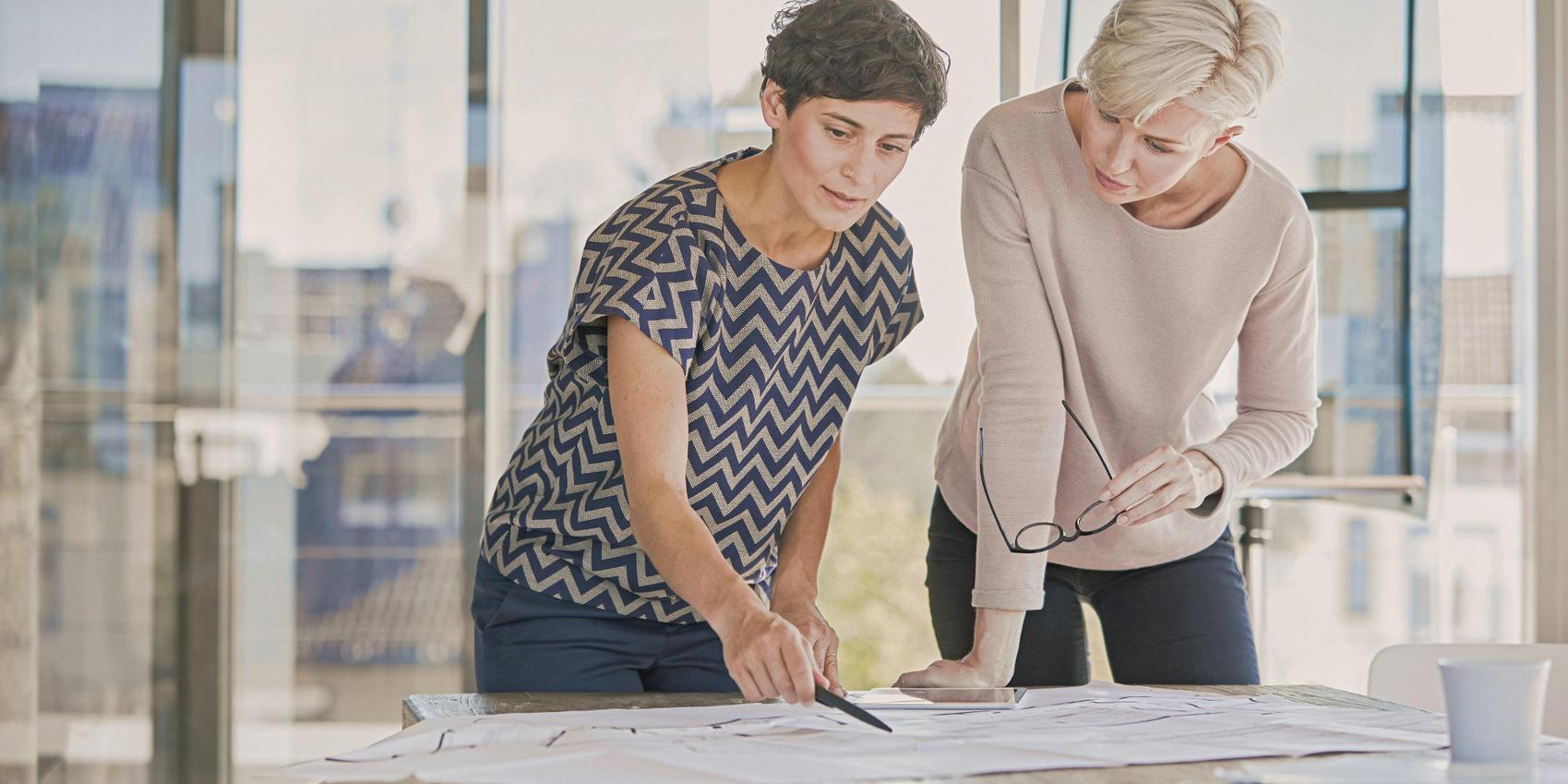 Zwei Frauen besprechen einen Bebauungsplan.
