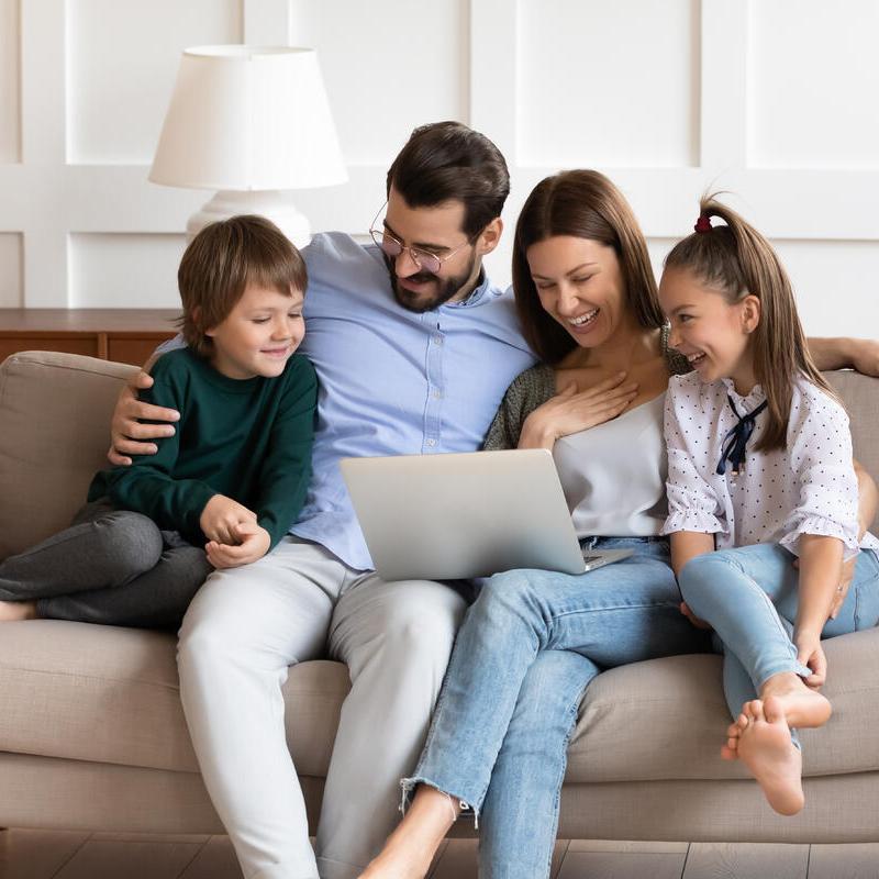 Sorglose Familie auf der Couch - dank Bauherren-Haftpflichtversicherung