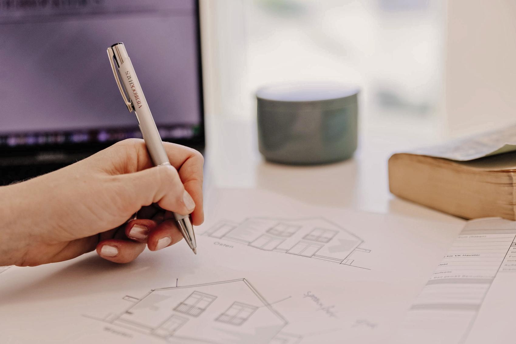 Bauplanung mit einer Hand, die einen Stift hält
