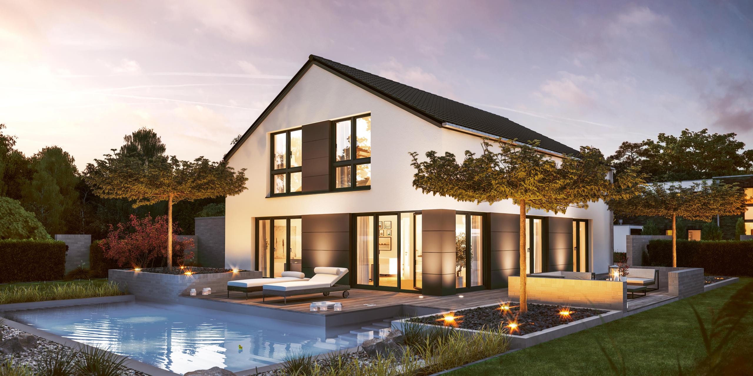 Rückansicht eines Einfamilienhauses mit zwei vollen Stockwerken und vielen bodentiefen Fenstern mit weißer, verputzter Fassade. Im Garten ist ein Pool und eine große Terrasse über Eck. Es handelt sich um das Edition 600 von Viebrockhaus