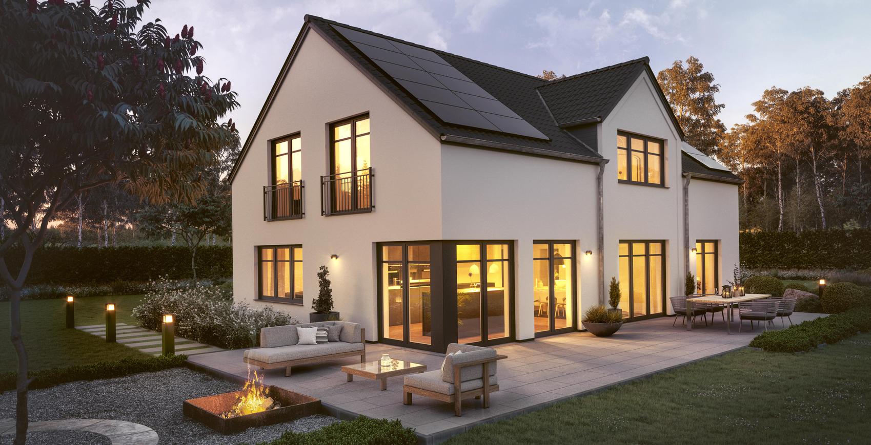 Modernes Einfamilienhaus von Viebrockhaus im Abendlicht mit brennender Feuerschale auf der Terrasse