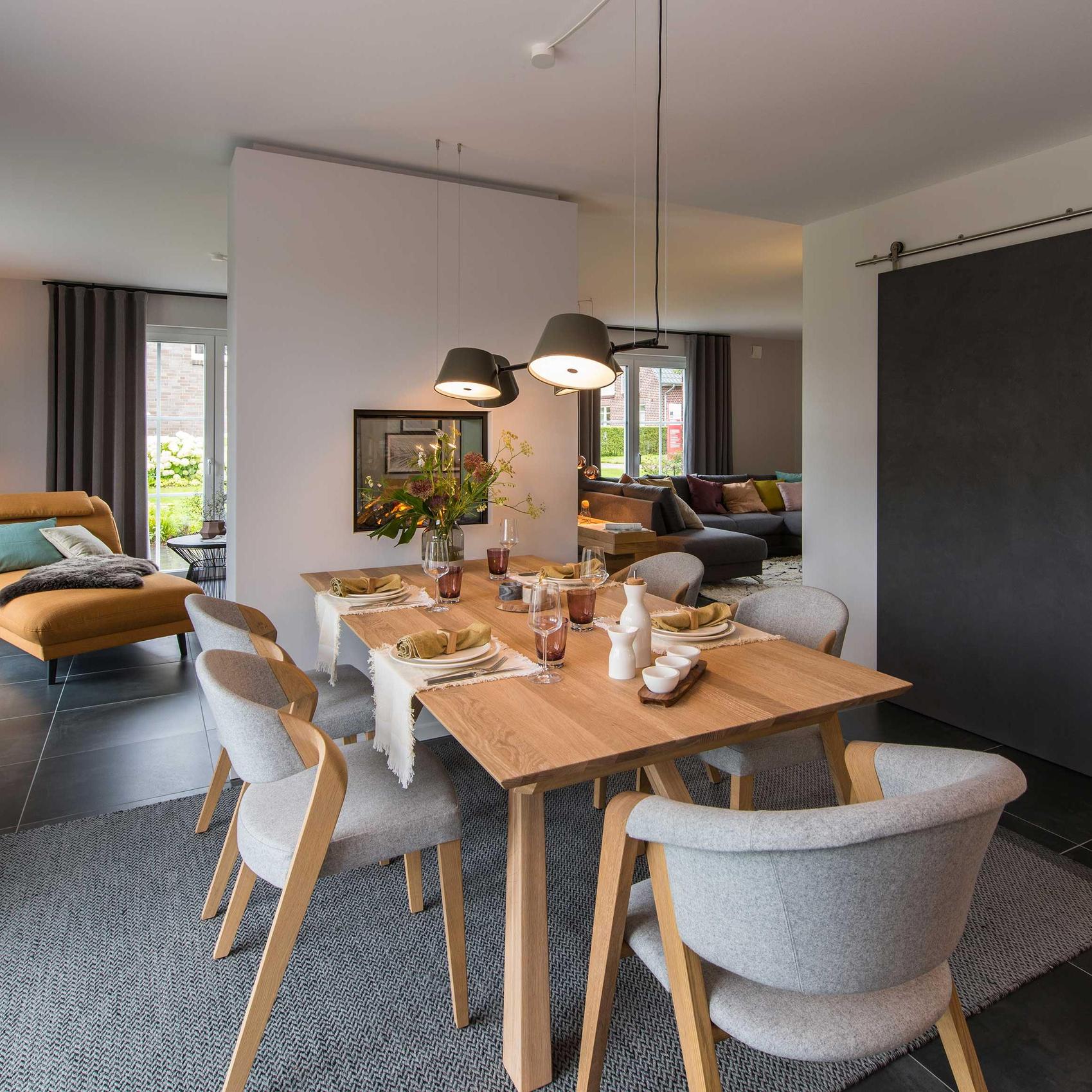 Blick in einen offenen Essbereich mit Holztisch und Polsterstühlen