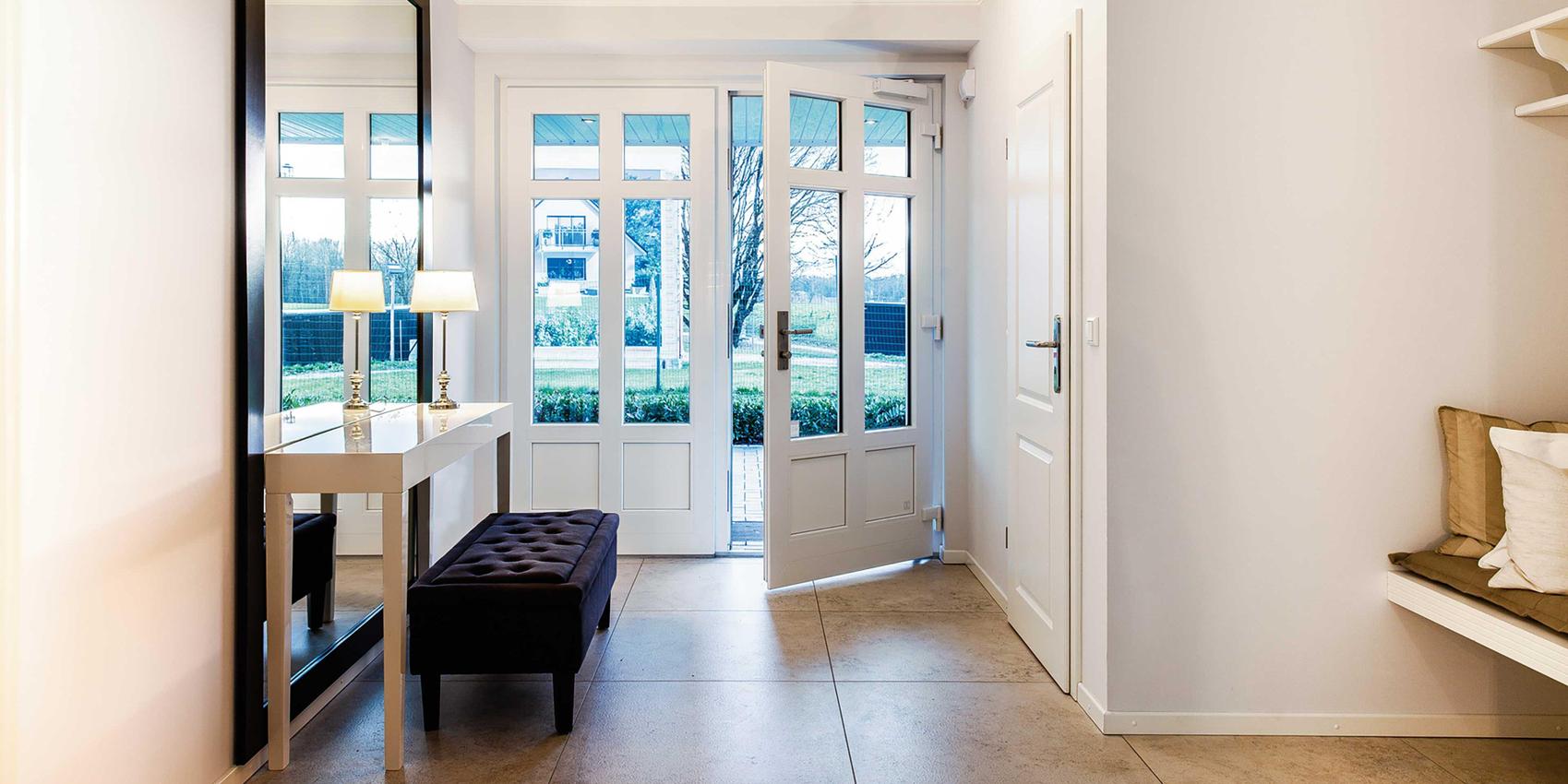 Blick von innen durch den Eingangsbereich zu einer offenen Haustür.