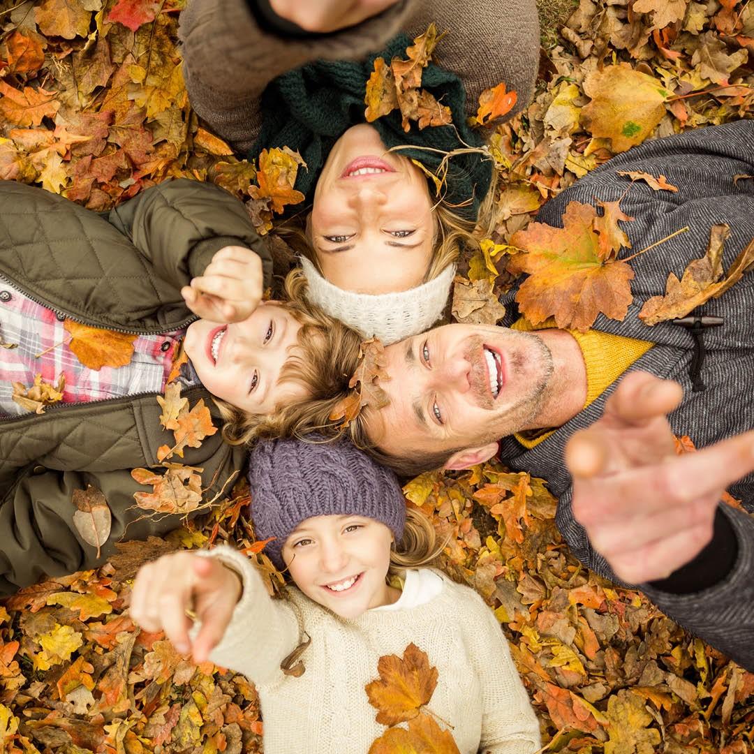 Glückliche Familie liegt im Herbstlaub