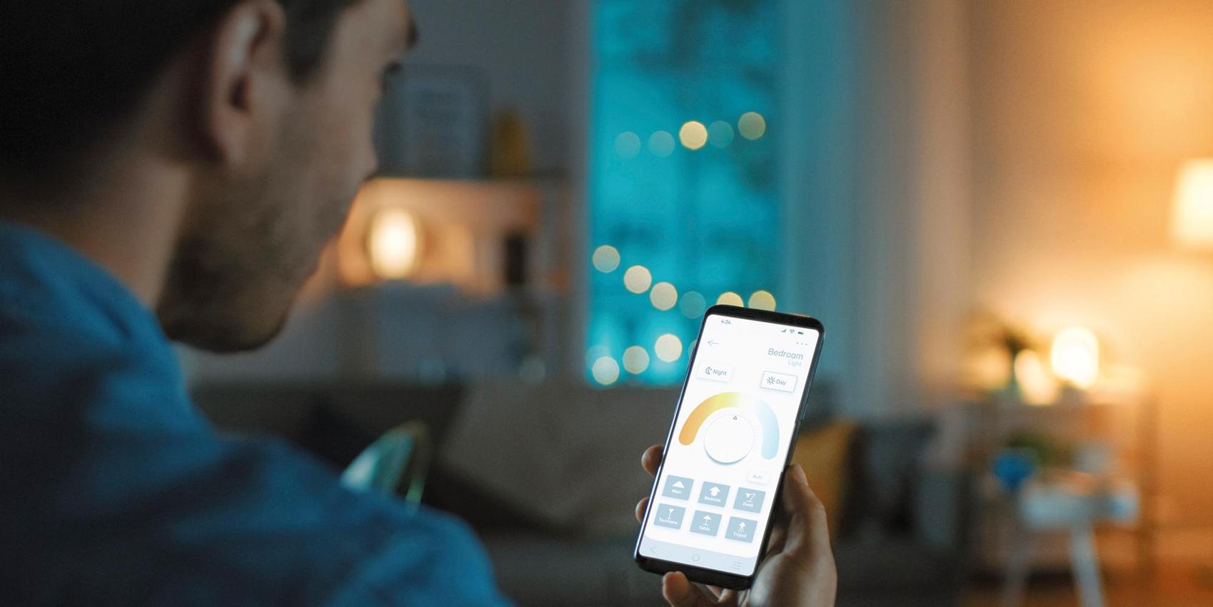 Mann schaut aufs Handy, das er in der Hand hält