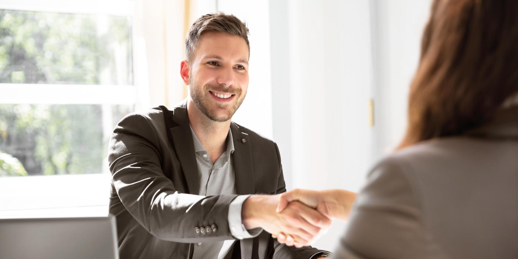 Berater und Kundin geben sich die Hand