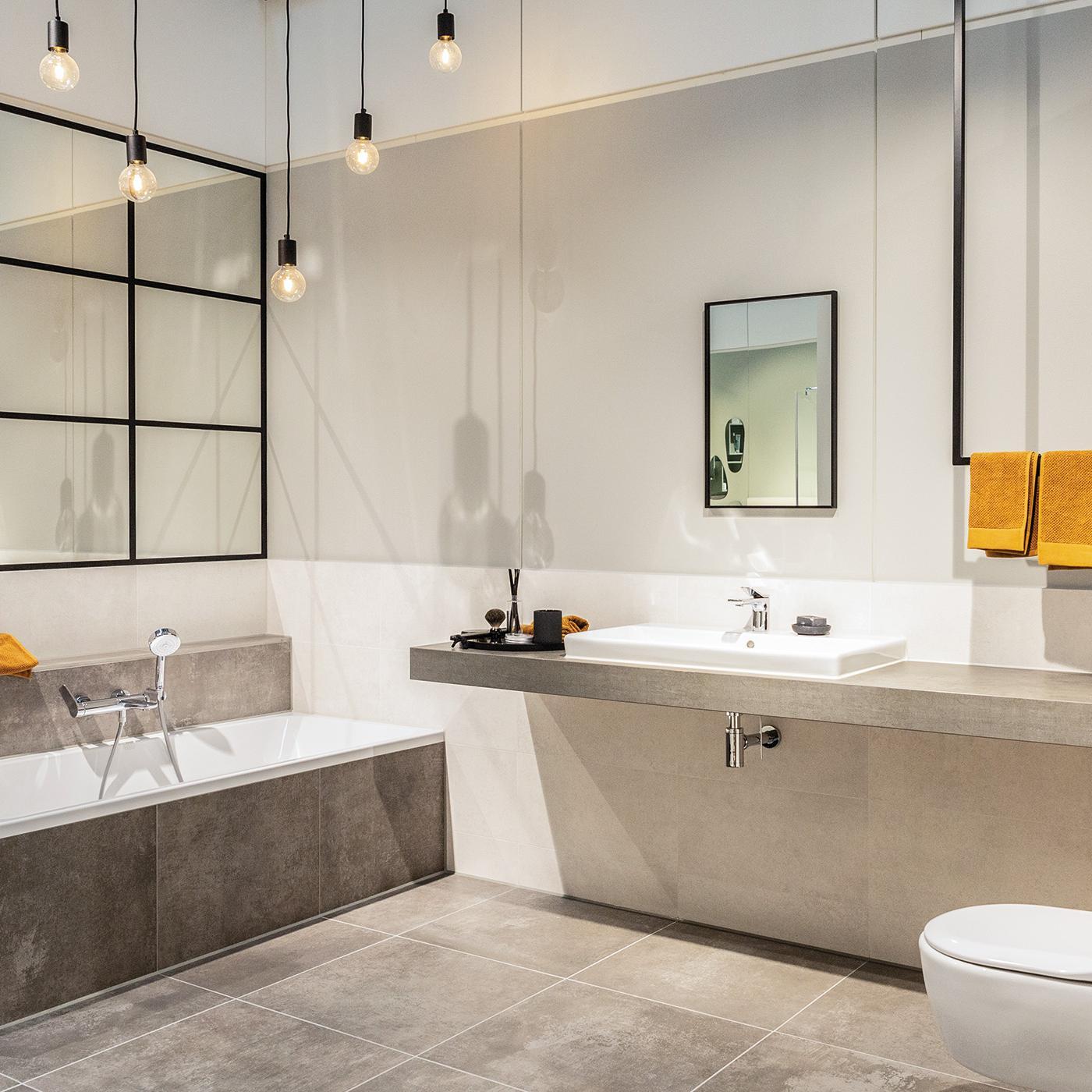 Modernes Badzimmer mit Badewanne und großen Spiegelflächen in einer Bemusterungshalle von Viebrockhaus