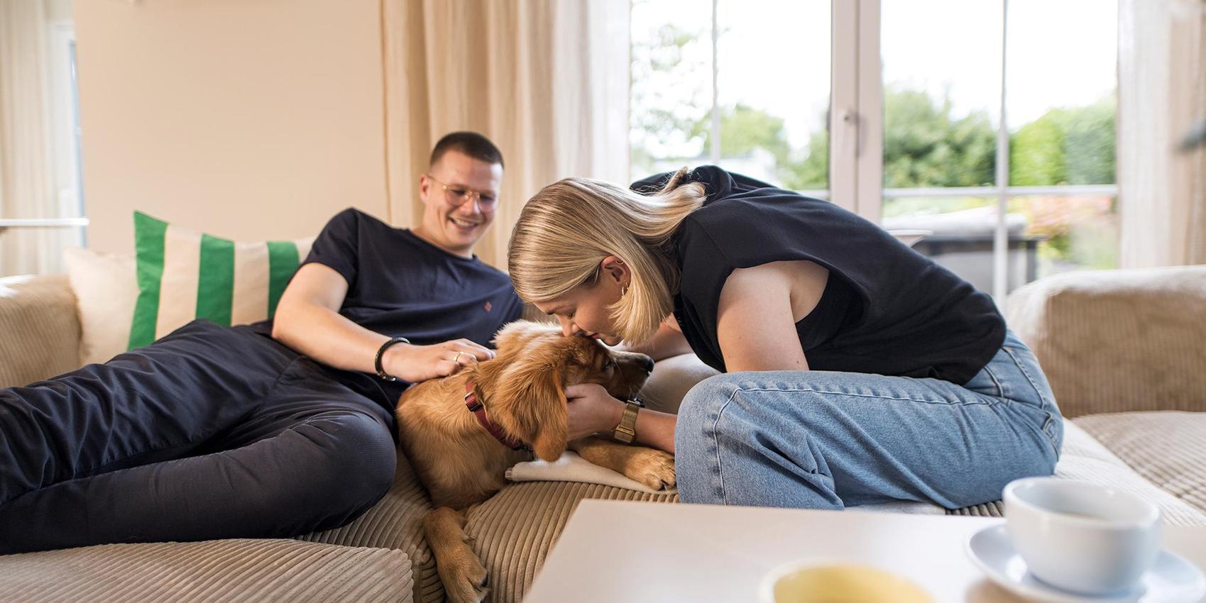 Ein Paar mit Hund auf dem Sofa
