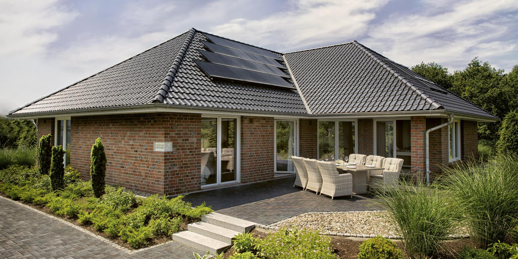 Rückansicht des Bungalows Maxime 550 B mit Terrasse und Photovoltaik auf dem Dach