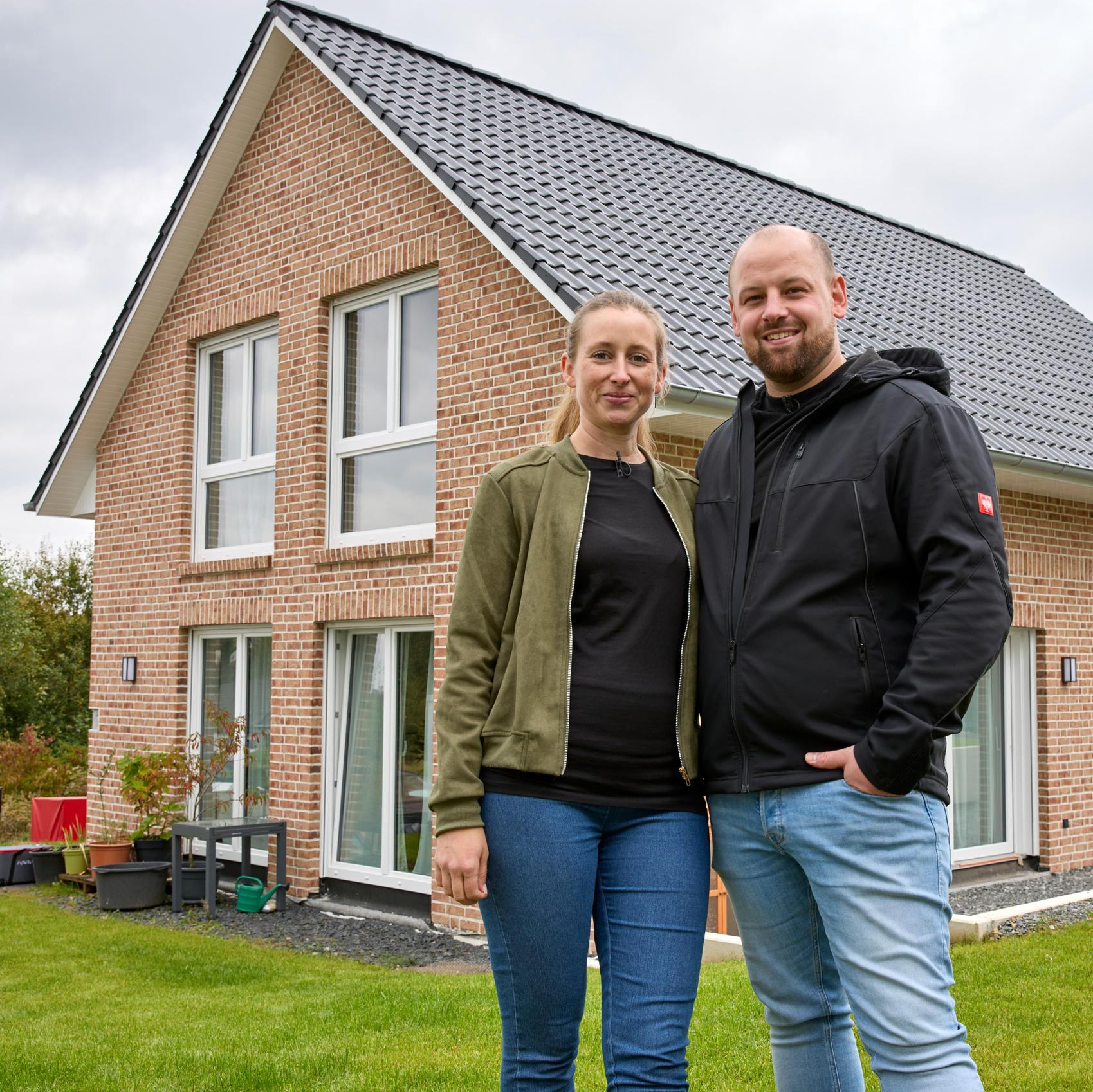 BauherrInnen vor fertig eingedecktem und gedämmten Dach