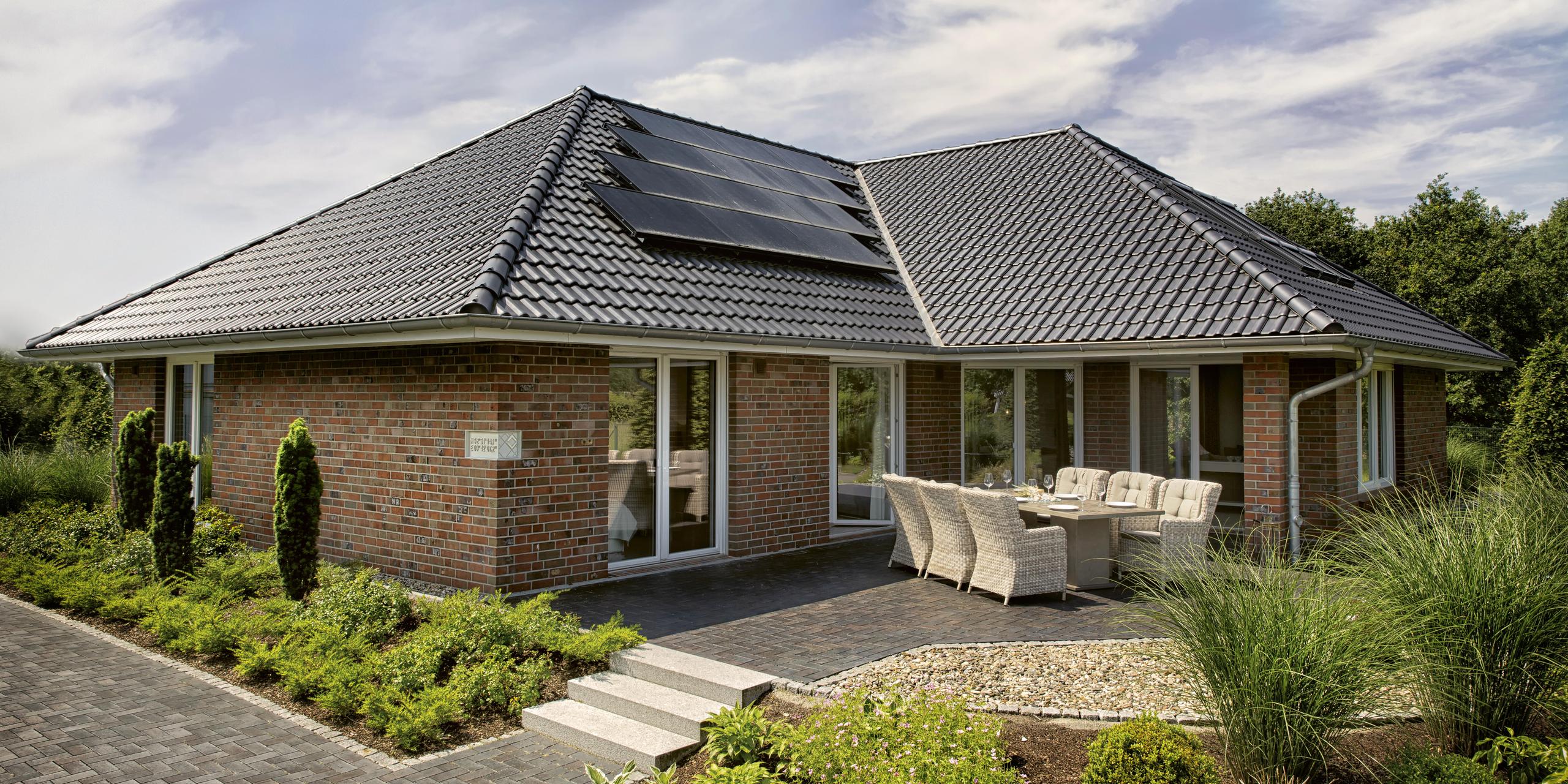 Rückansicht des Bungalows Maxime 550 B mit Terrasse und Photovoltaik auf dem Dach