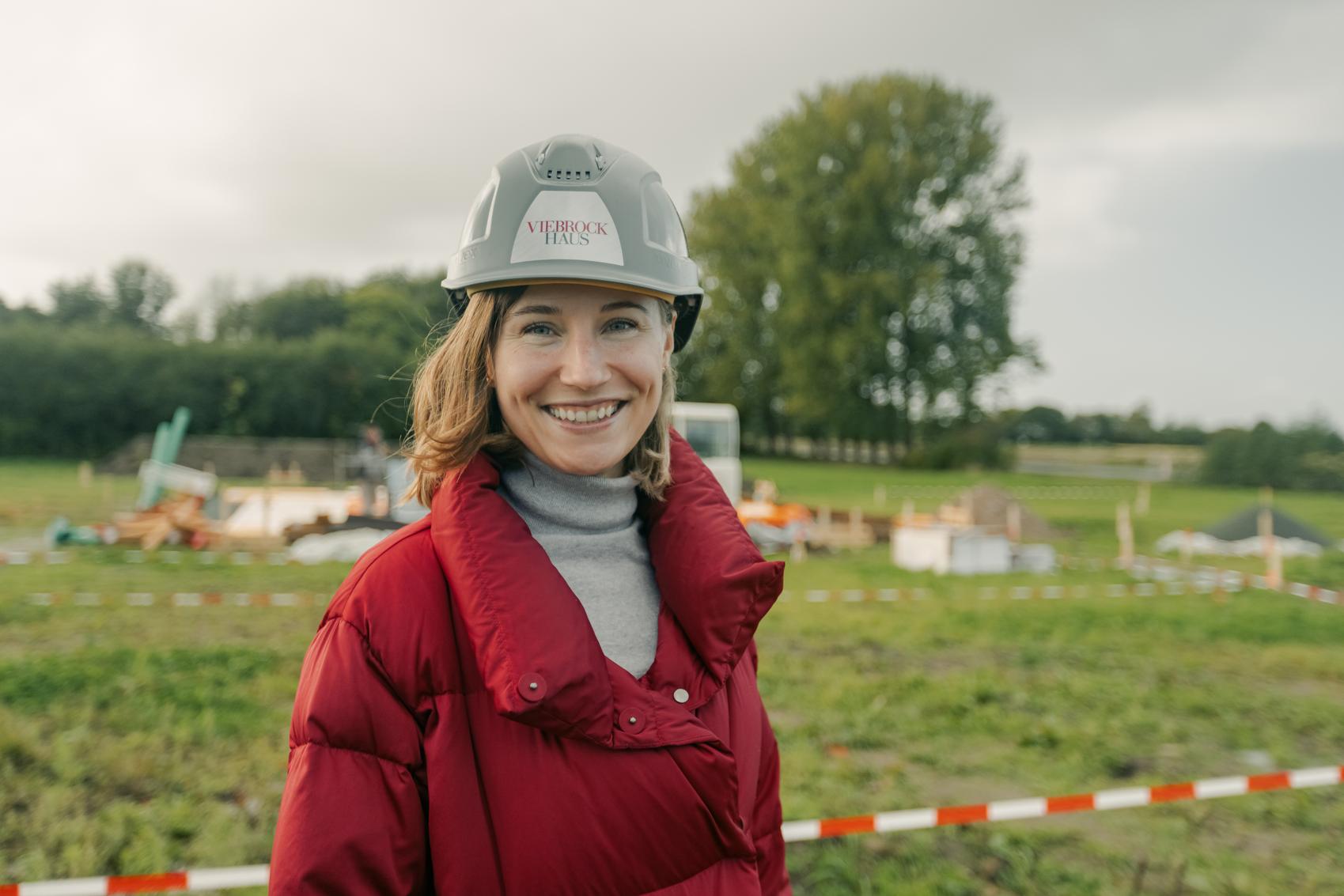 Frau mit Viebrockhaus-Helm steht vor einer Baustelle
