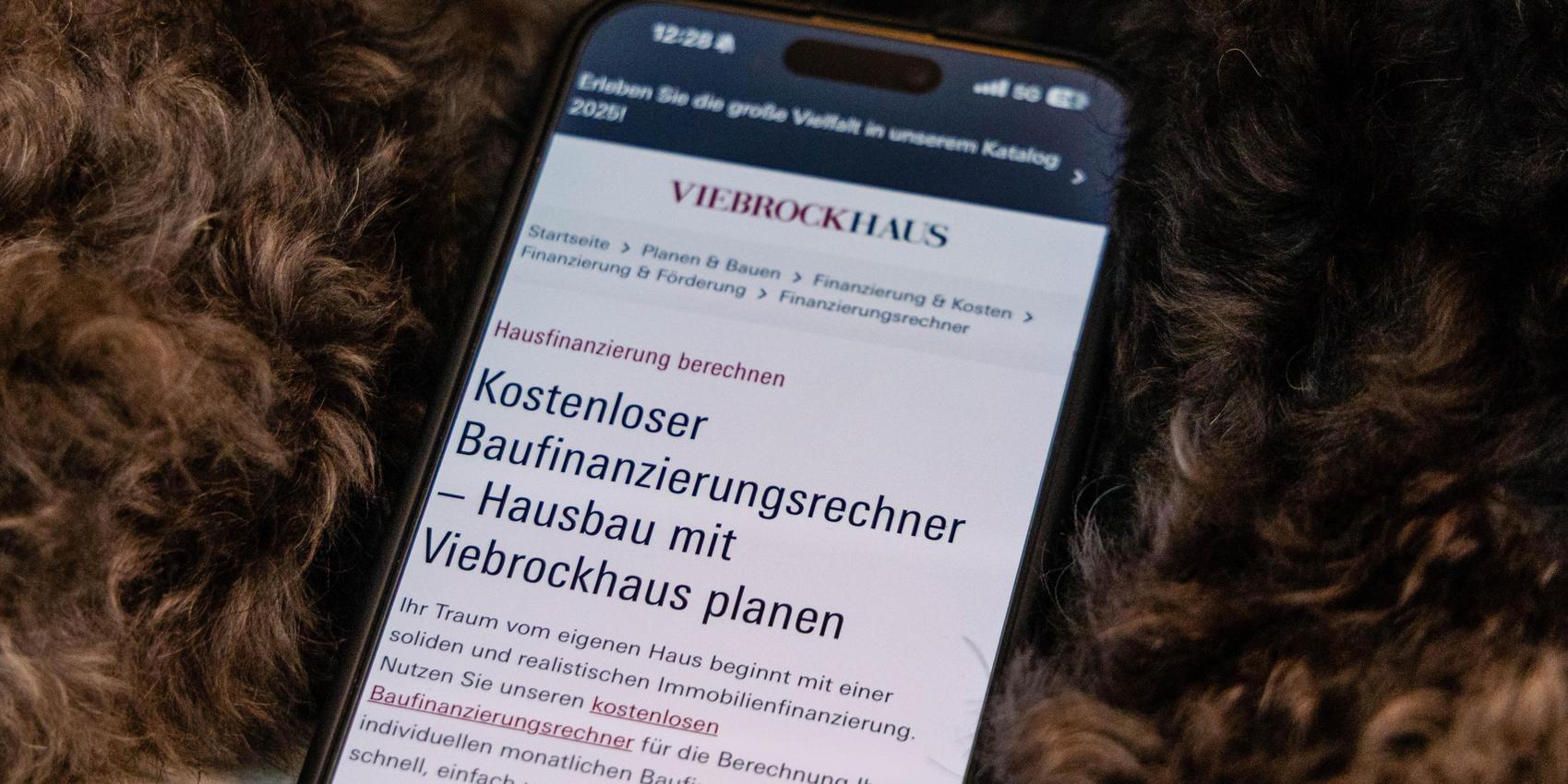 Handy mit Baufinanzierungsrechner.