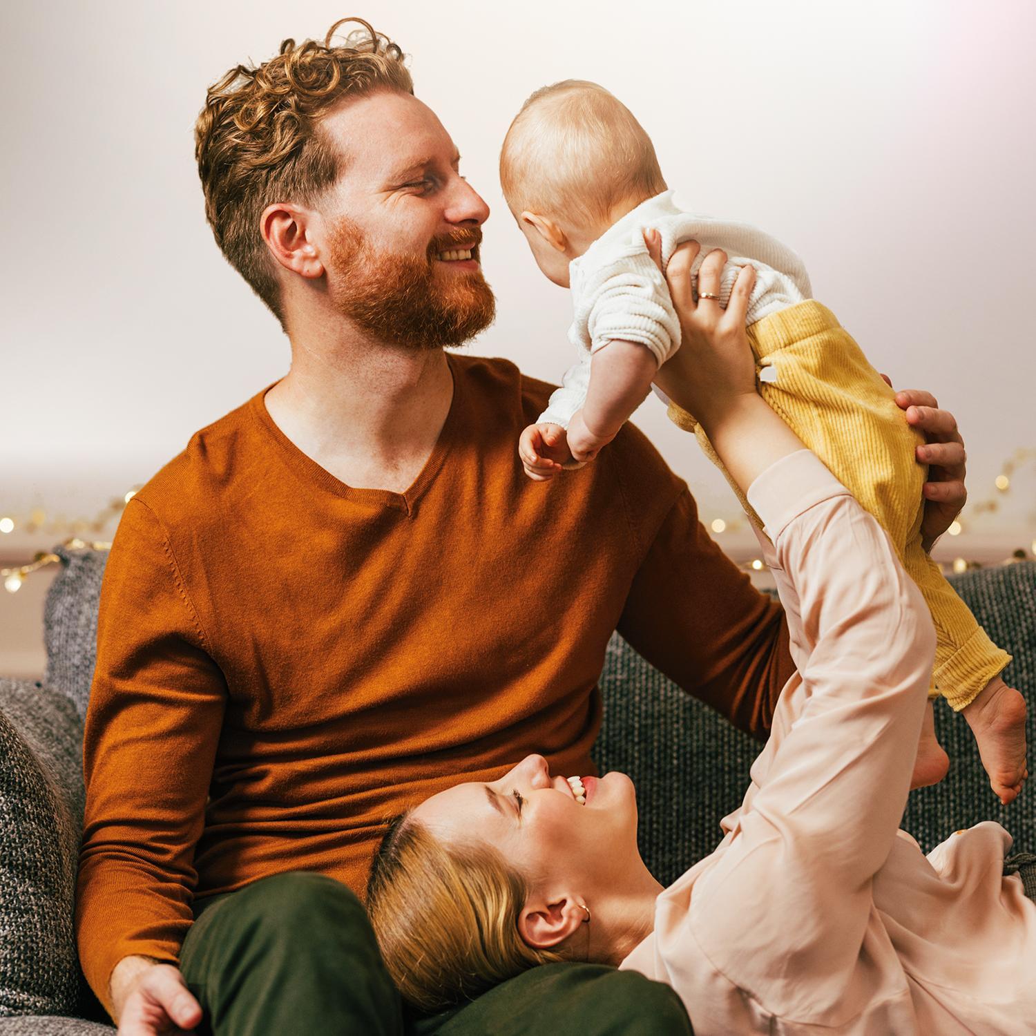 Glückliche Familie mit Baby auf dem Sofa