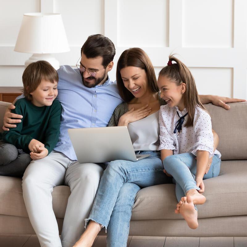 Familie testet Online-Finanzierungsrechner am Laptop