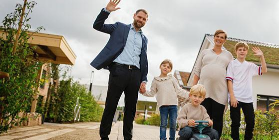 5-köpfige Familien vor Häusern