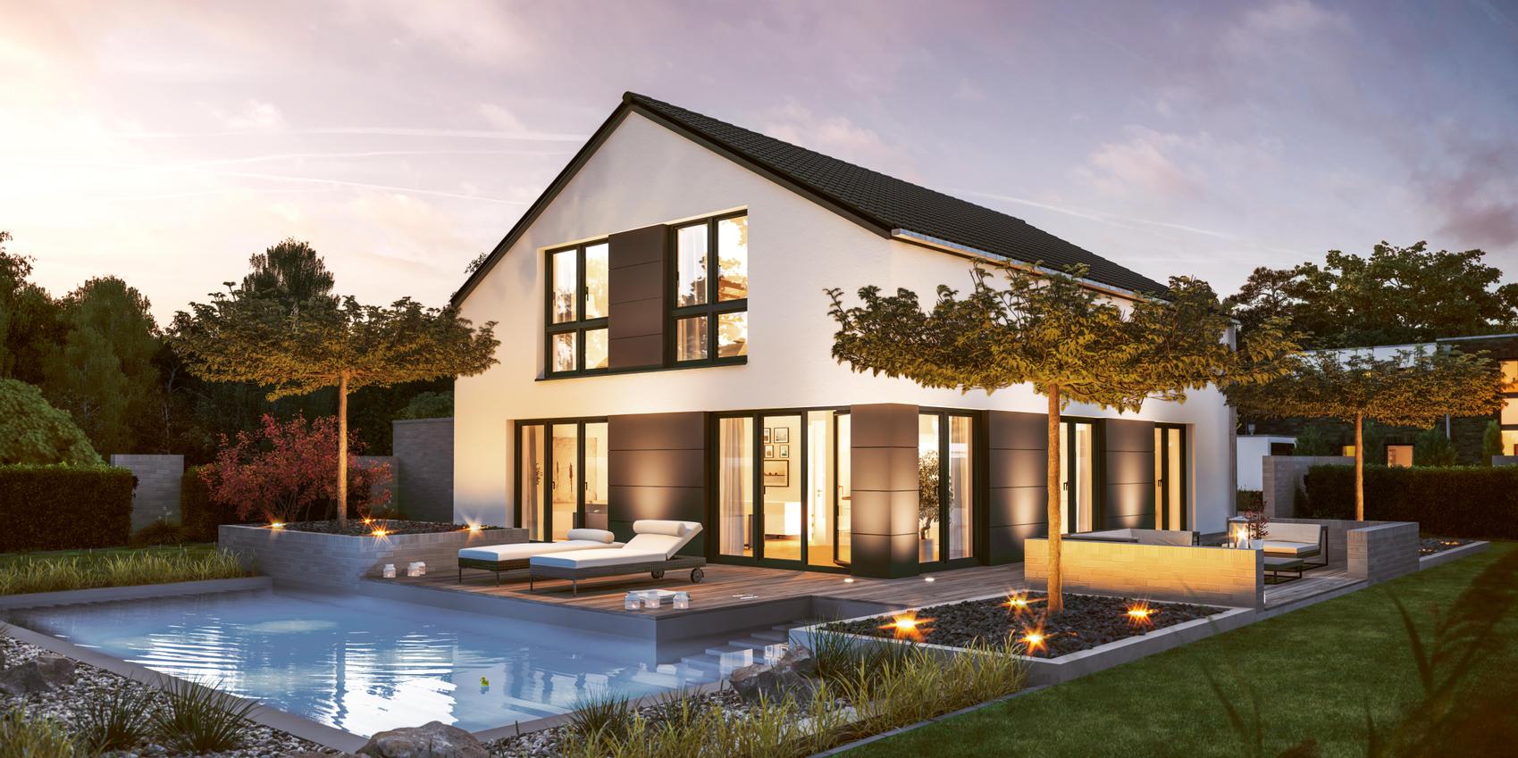 Rückansicht eines Einfamilienhauses mit zwei vollen Stockwerken und vielen bodentiefen Fenstern mit weißer, verputzter Fassade. Im Garten ist ein Pool und eine große Terrasse über Eck. Es handelt sich um das Edition 600 von Viebrockhaus