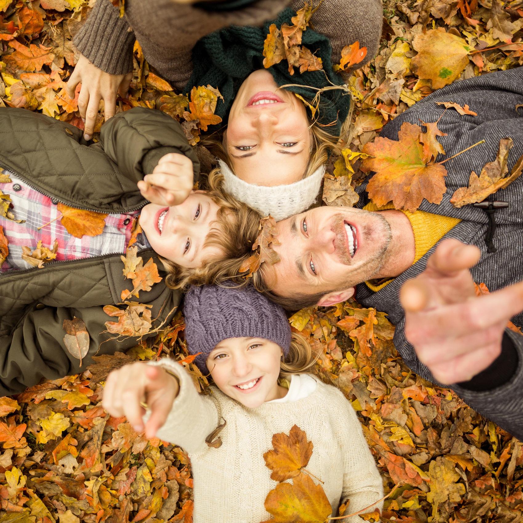 Glückliche Familie liegt im Herbstlaub