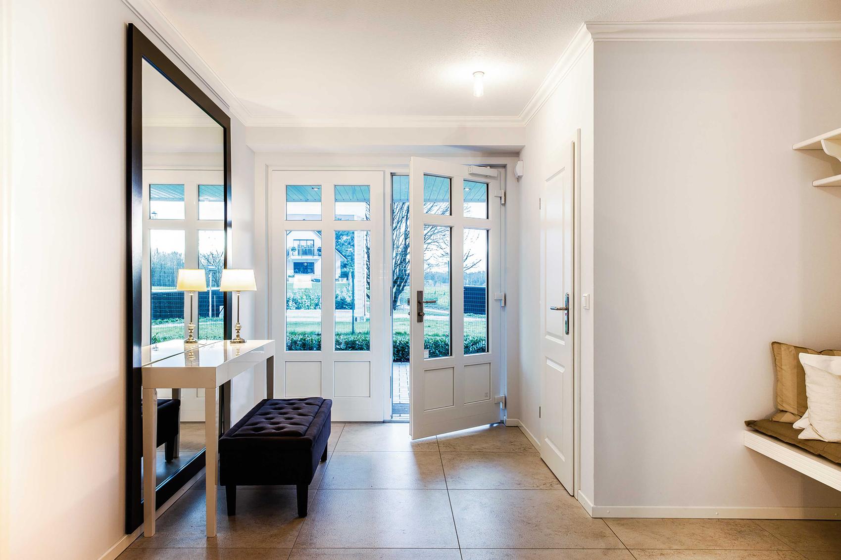 Blick von innen auf den Eingangsbereich und eine geöffnete Haustür.